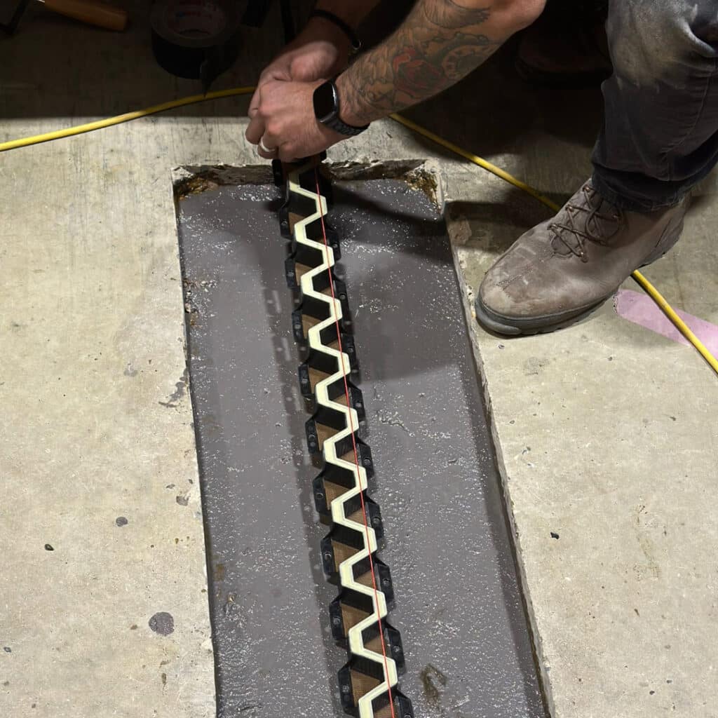 Man installing metal joint into concrete floor