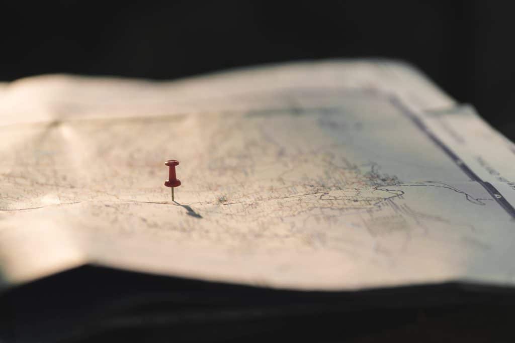 Red push pin in paper map