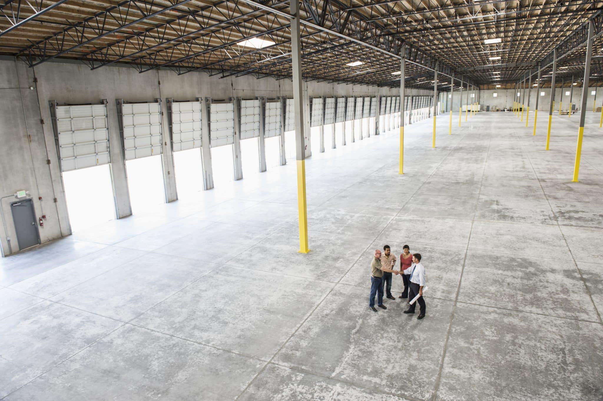 Interior of a large warehouse with a concrete floor.